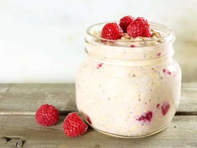 Overnight oats med proteinpulver och hallon i burk, perfekt för en snabb och näringsrik frukost.