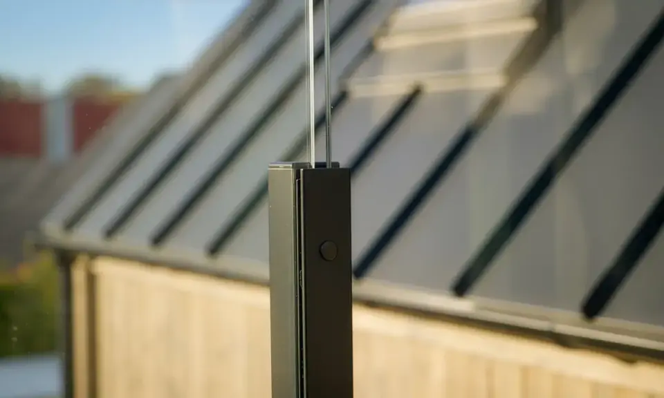 Modern glasräcke ger vindskydd altan inspiration. Enkel design med svart stolpe och glas.