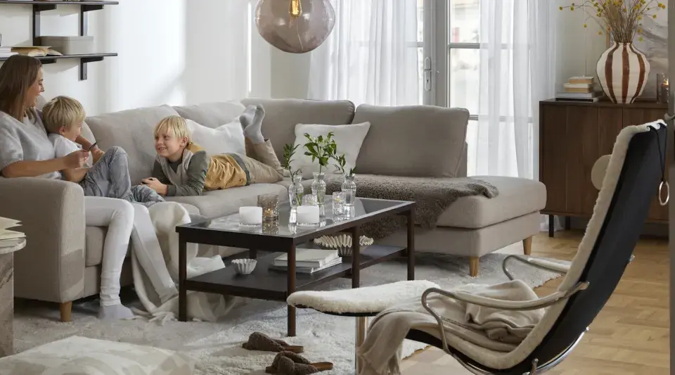 Familj myser i soffan. För att skydda tyget och göra det lättare att rengöra, kan man impregnera soffan.