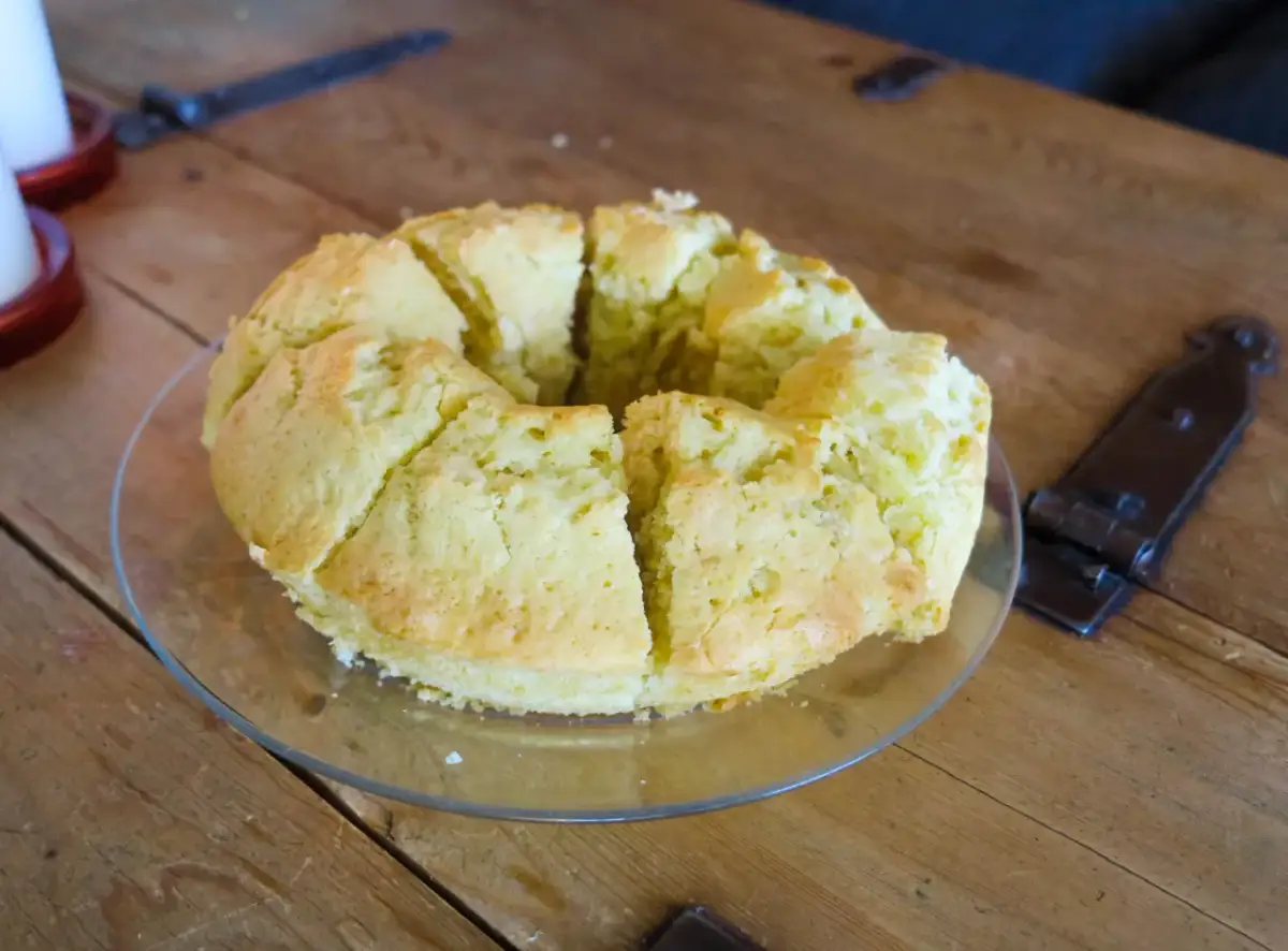 En saftig sockerkaka, uppskuren i bitar på ett fat, ligger på ett rustikt träbord.