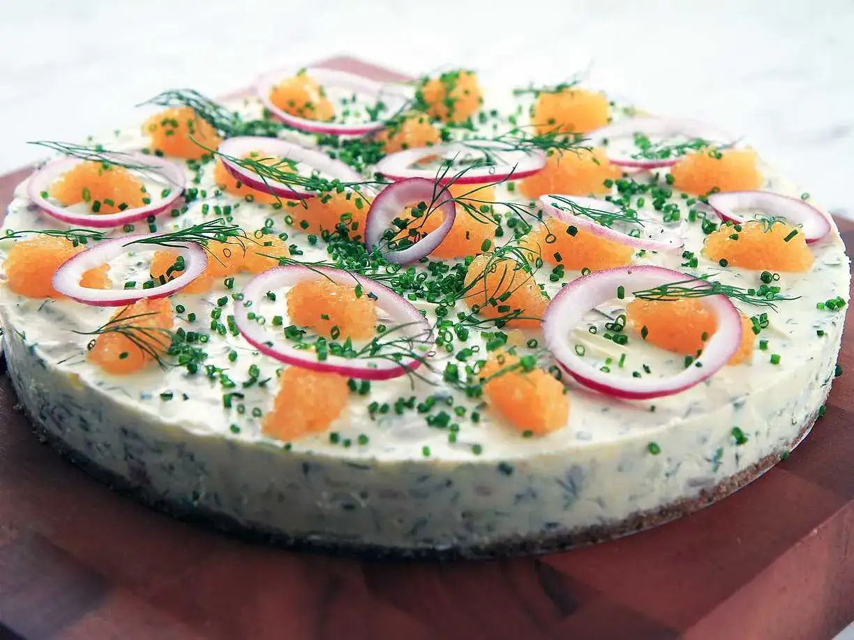 En vacker silltårta på kavring, dekorerad med rom, rödlök och dill. Perfekt för midsommar!