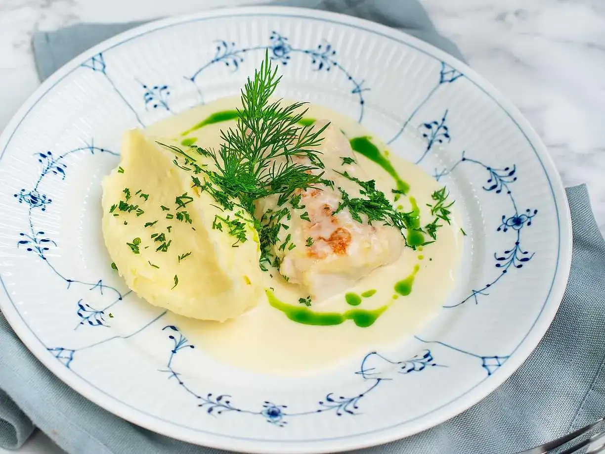 En vacker tallrik med en krämig torsk, potatismos och dill. Ett perfekt torsk recept för en festlig middag.
