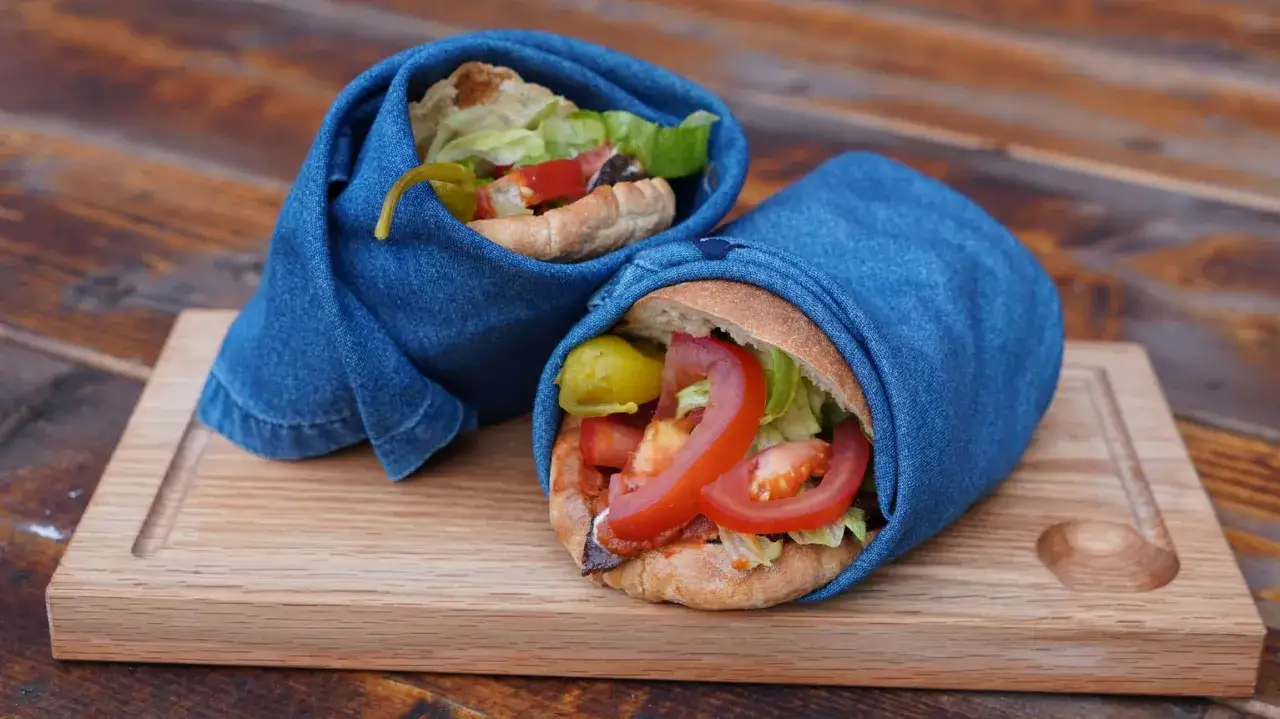 Tv&aring; kebabrullar med tomat, sallad och paprika, inslagna i jeans p&aring; en tr&auml;bricka. Ett enkelt kebab recept!