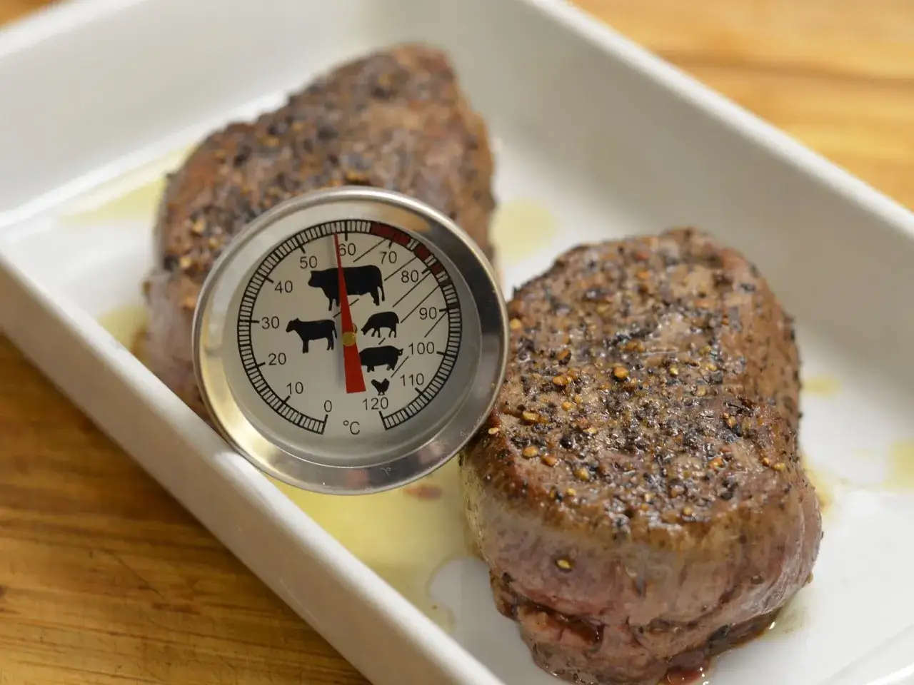Perfekt oxfile recept: två saftiga biffar med kött-termometer som visar innertemperaturen.