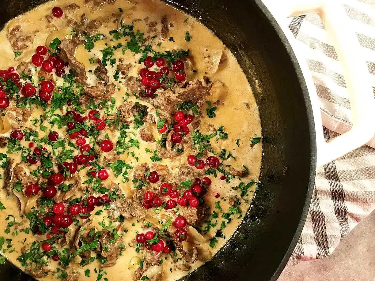 Krämig renskav med lingon och persilja, redo att serveras. Ett klassiskt renskav recept som passar perfekt till middagen.
