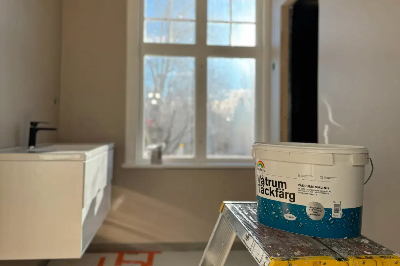En hink med Beckers V&aring;trum T&auml;ckf&auml;rg st&aring;r p&aring; en stege. Badrummet &auml;r under renovering, redo att m&aring;la v&aring;trum.