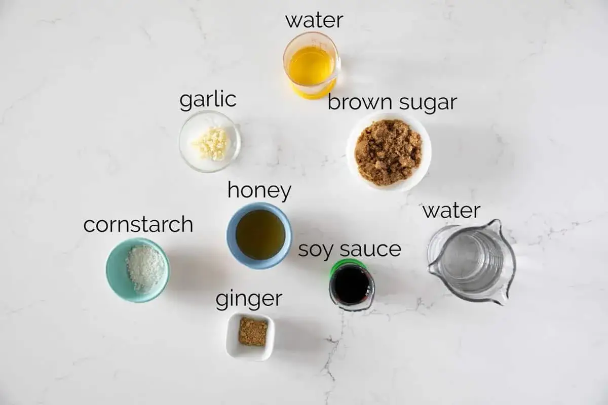 Ingredienser för ett enkelt teriyakisås recept: majsstärkelse, vitlök, honung, ingefära, sojasås, farinsocker och vatten.