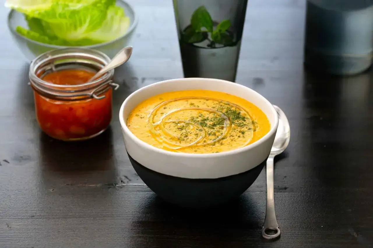 En krämig linssoppa med olivolja och örter, serverad med en liten burk med tillbehör. Ett perfekt linssoppa recept för en mysig middag.