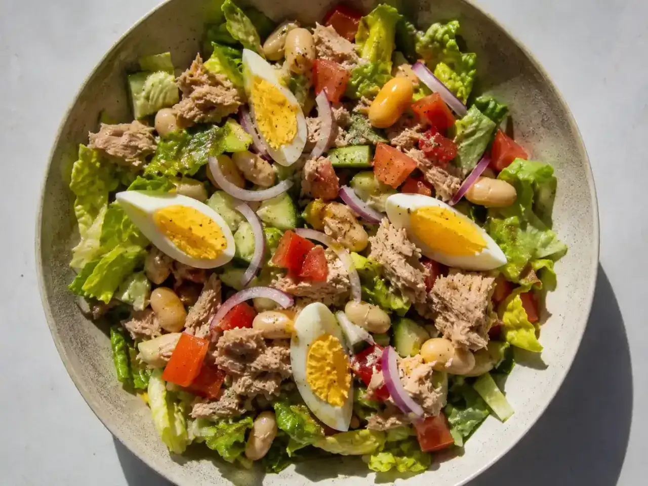 En fräsch tonfisk sallad med ägg, bönor, tomat, gurka och rödlök. Perfekt för en lätt lunch.
