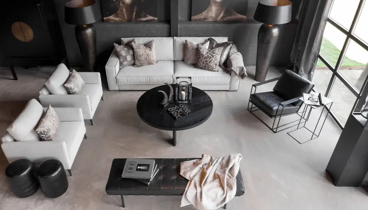 En stilren lounge med soffa, fåtöljer och ett runt soffbord. Perfekt för att skapa en ombonad känsla med second hand inredning.