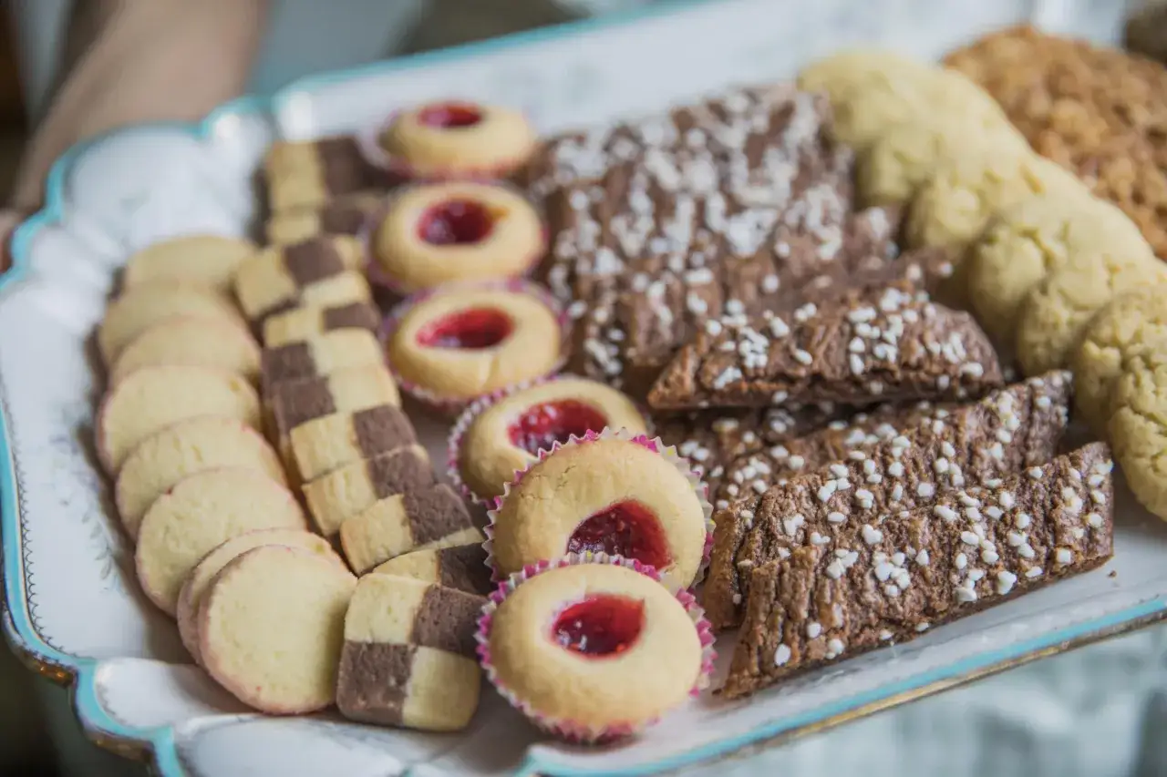 En bricka full med hembakade kakor, perfekta för fika. Här finns hallongrottor, rutiga drömmar och chokladkakor med pärlsocker. Ett härligt fika recept!