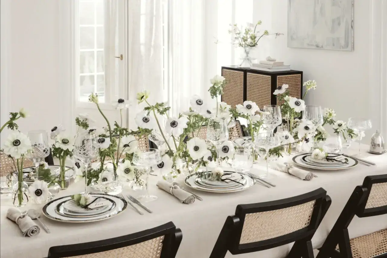 Vackert dukat bord med vita anemoneblommor och kristallglas, perfekt för att duka till midsommar.