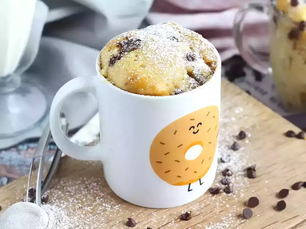 En fluffig muggkaka med vaniljsmak och chokladbitar, pudrad med florsocker. Perfekt för en snabb fika!