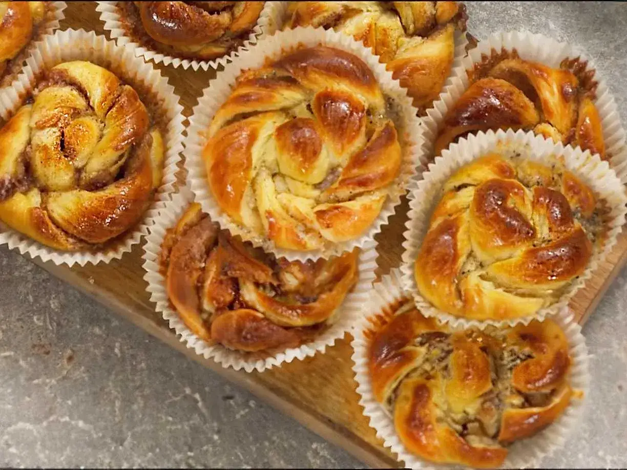 Nybakade bullar med mandelmassa, vackert snurrade och glansiga, redo att avnjutas.