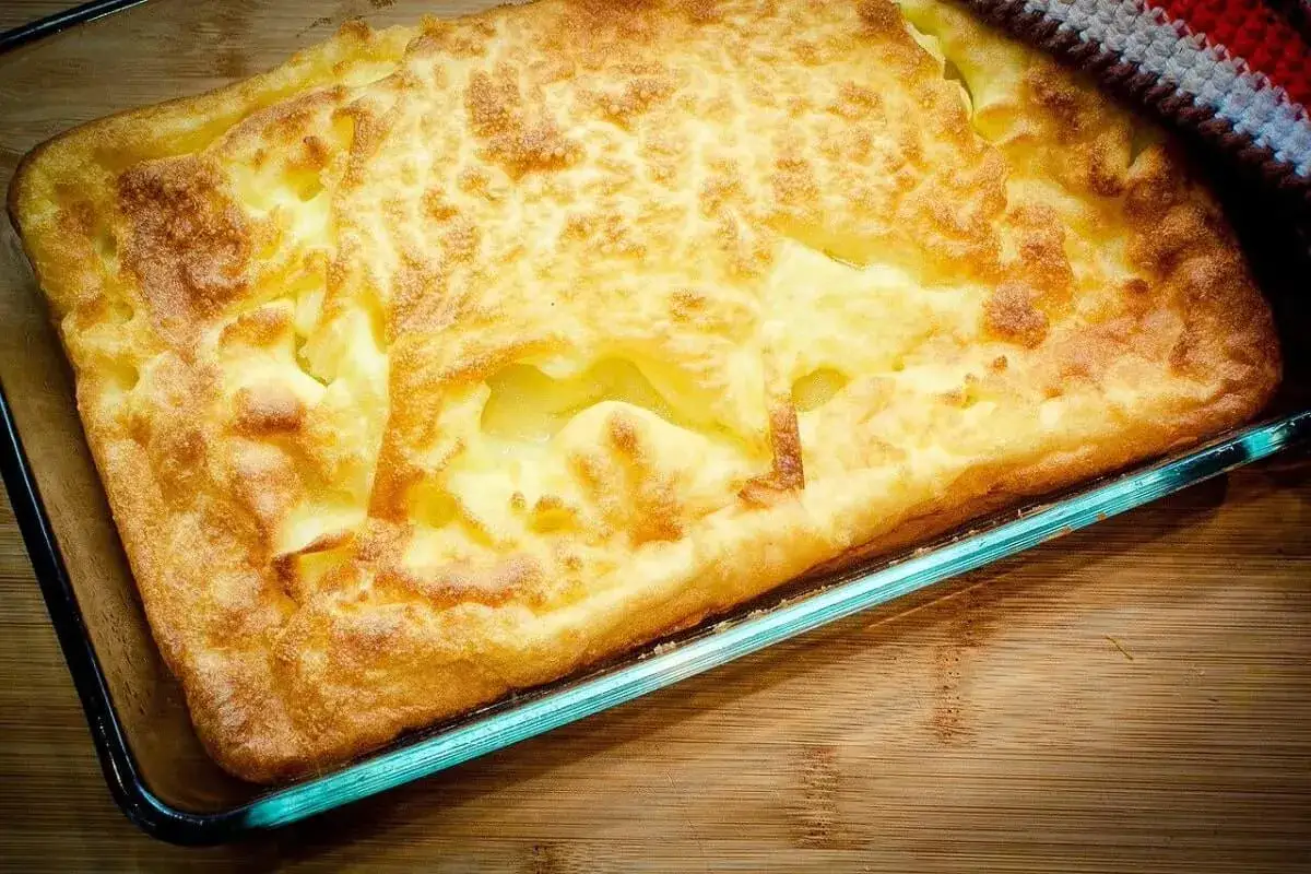 En gyllene, fluffig ugnspannkaka i en glasform, redo att serveras. Ett perfekt recept för en mysig fika.